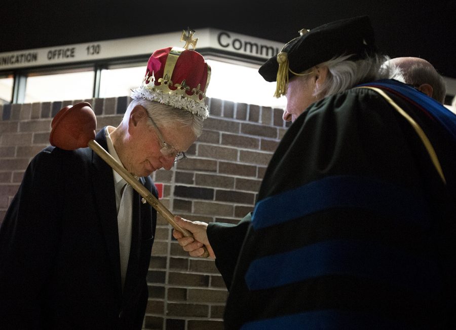 Communication department head Helen Sterk knights Dr. Carl Kell, professor emeritus, during his chair dedication ceremony Feb. 9 on the first floor of the fine arts center.