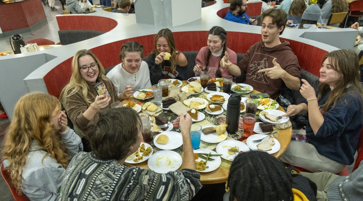 A group of friends laughs as they eat during the annual Freshgiving event on Thursday, Nov. 21, 2024. 