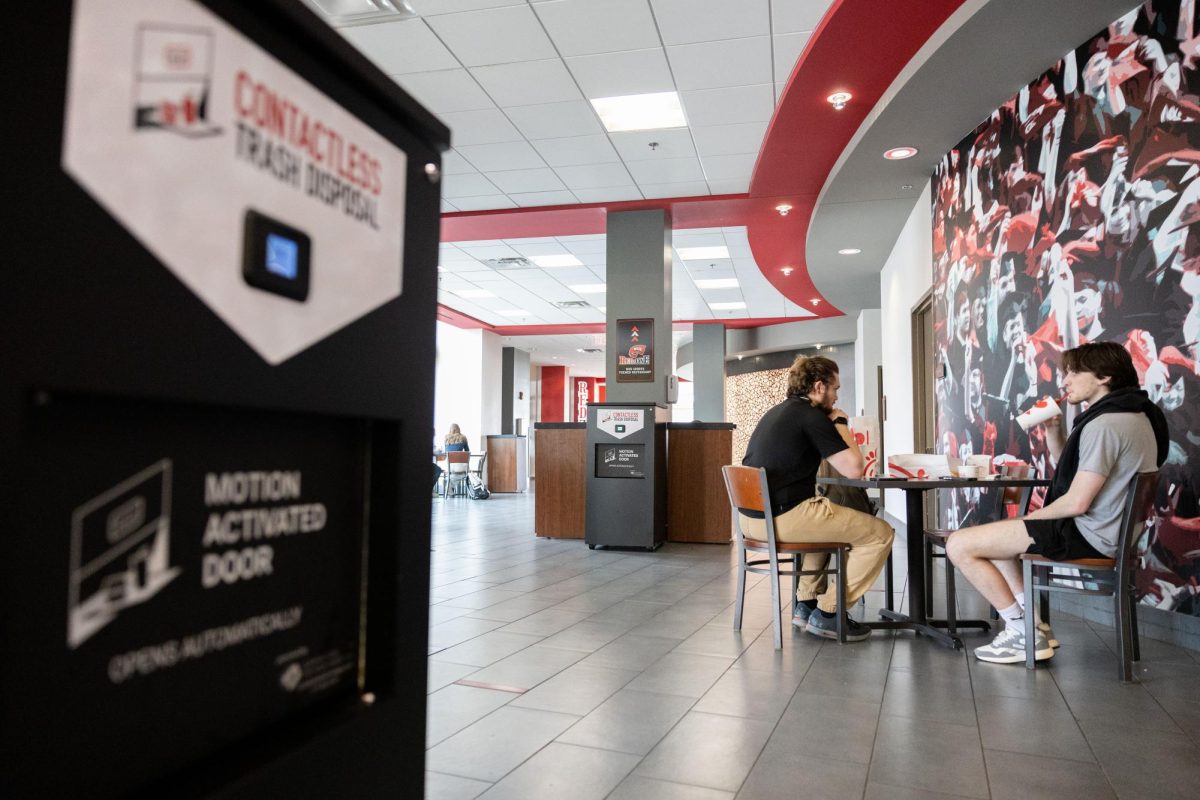 Senior Harrison Resing, left, and alumni Thomas McCoy eat lunch in DSU on Thursday, Feb. 6, 2025 near the new contactless trash receptacles have been placed in DSU. The new trash cans claim to reduce emissions from garbage trucks, use less than $8 of electricity a year and decrease the volume of trash that ends up in landfills. 
