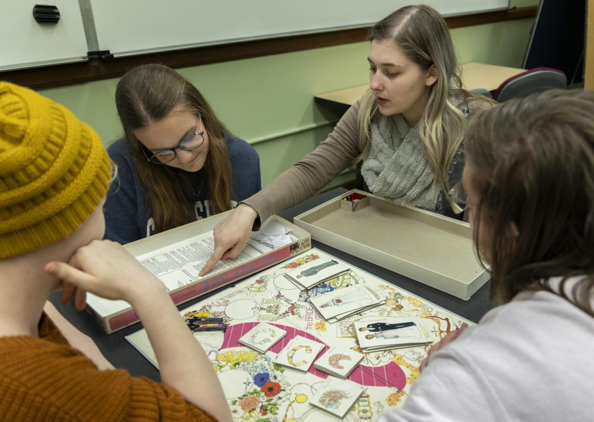 Eden Pendley, a senior history and social studies major (left) and Elena Carder, senior history major (right), look over the rules of The Bride Game before playing in Cherry Hall on Monday, Feb. 10, 2025.