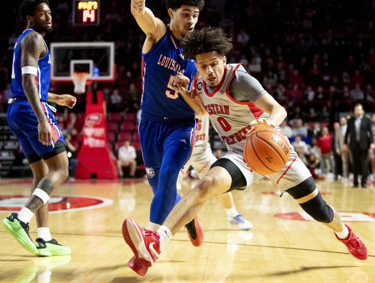 Western Kentucky Hilltoppers guard Braxton Bayless (0) drives the ball to the basket against opposition from Louisiana Tech Bulldogs guard Al Green (5) during WKU’s game against Louisiana Tech on Saturday, Feb. 22, 2025. Bayless had 9 points at the half to contribute to WKU’s scoring lead against Louisiana Tech 24-19. 