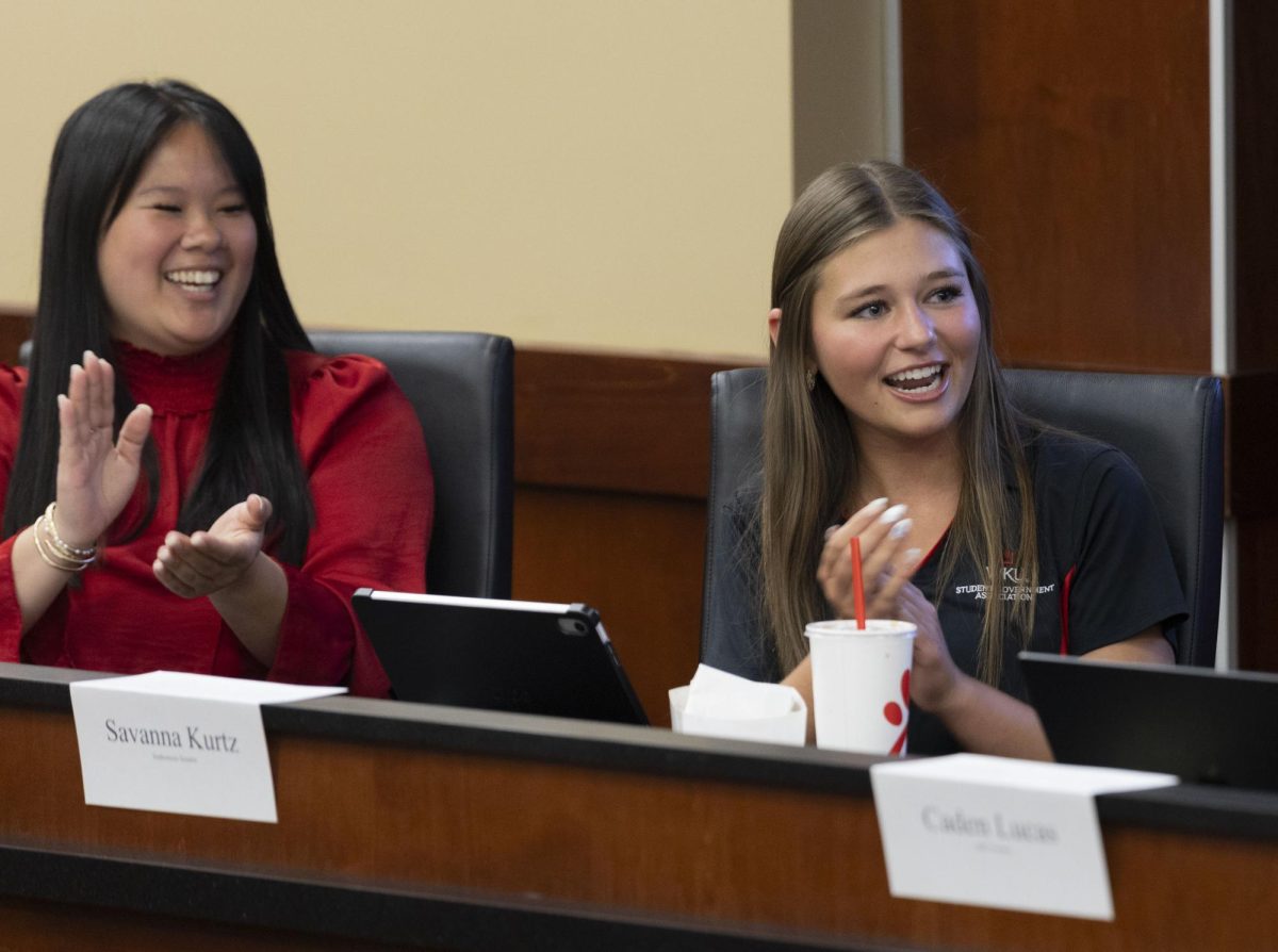 Community Relations Officer Jenna Wells (left) and Enrollment and Student Experience Officer Savanna Kurtz (right) applaud after a report by Legislative Operations Committee Officer Caden Lucas in senate chambers on Tuesday, April 15, 2025. 