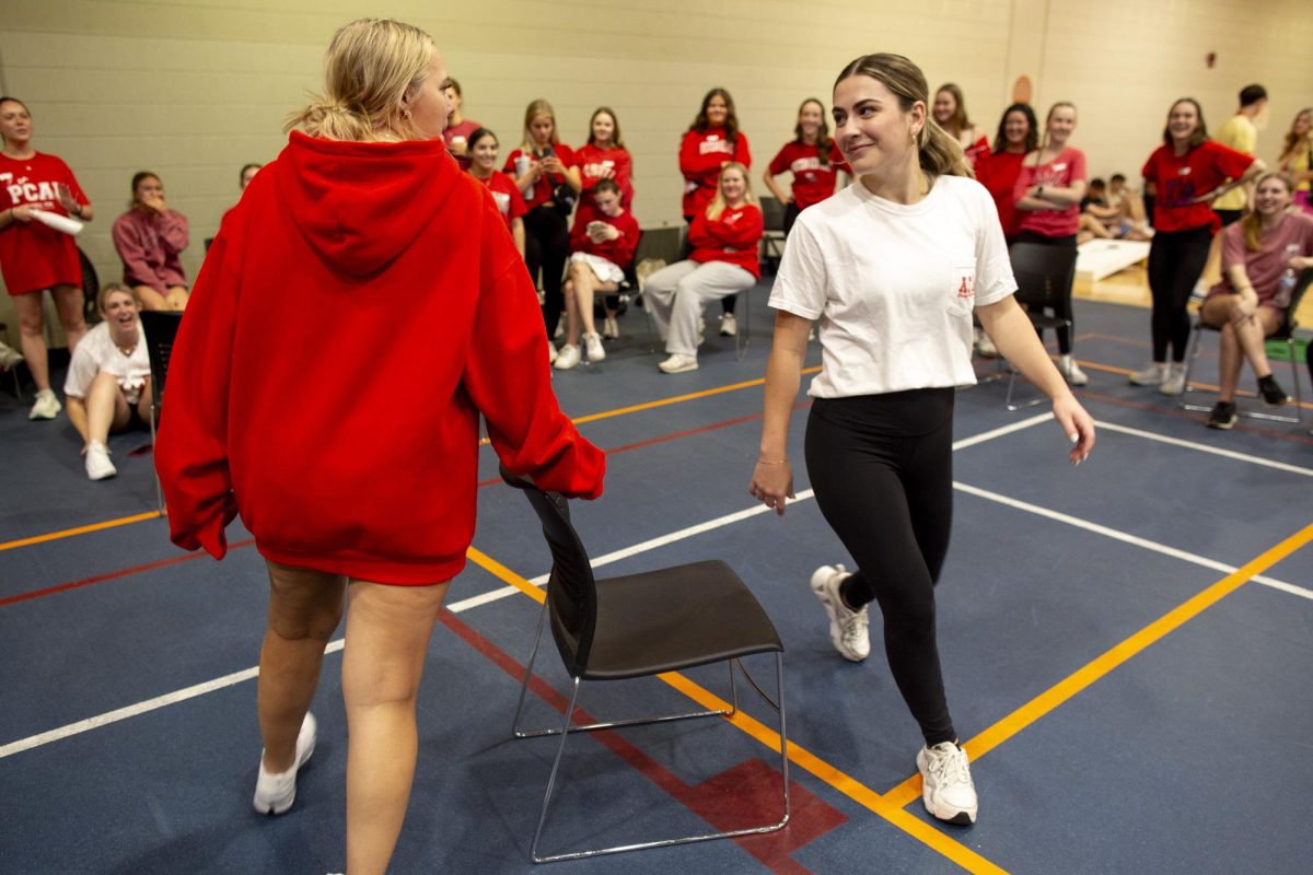Alpha Gamma Delta sorority sisters Elyse Bryan (left) and Erin Mehringer (right) stare each other down in a competitive game of musical chairs during the “Midnight on the Hill” fundraising event for St. Jude Children’s Research Hospital in the Preston Fitness Center on Friday, April 4, 2025. “We were getting dizzy,” Bryan said, after winning the final chair by force, “She beat me in dodgeball so I had to beat her at musical chairs.” 