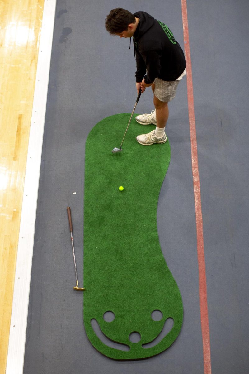 A “Midnight on the Hill” attendee attempts a putt in between games during the MOTH fundraising event for St. Jude Children’s Research Hospital in the Preston Fitness Center on Friday, April 4, 2025. 