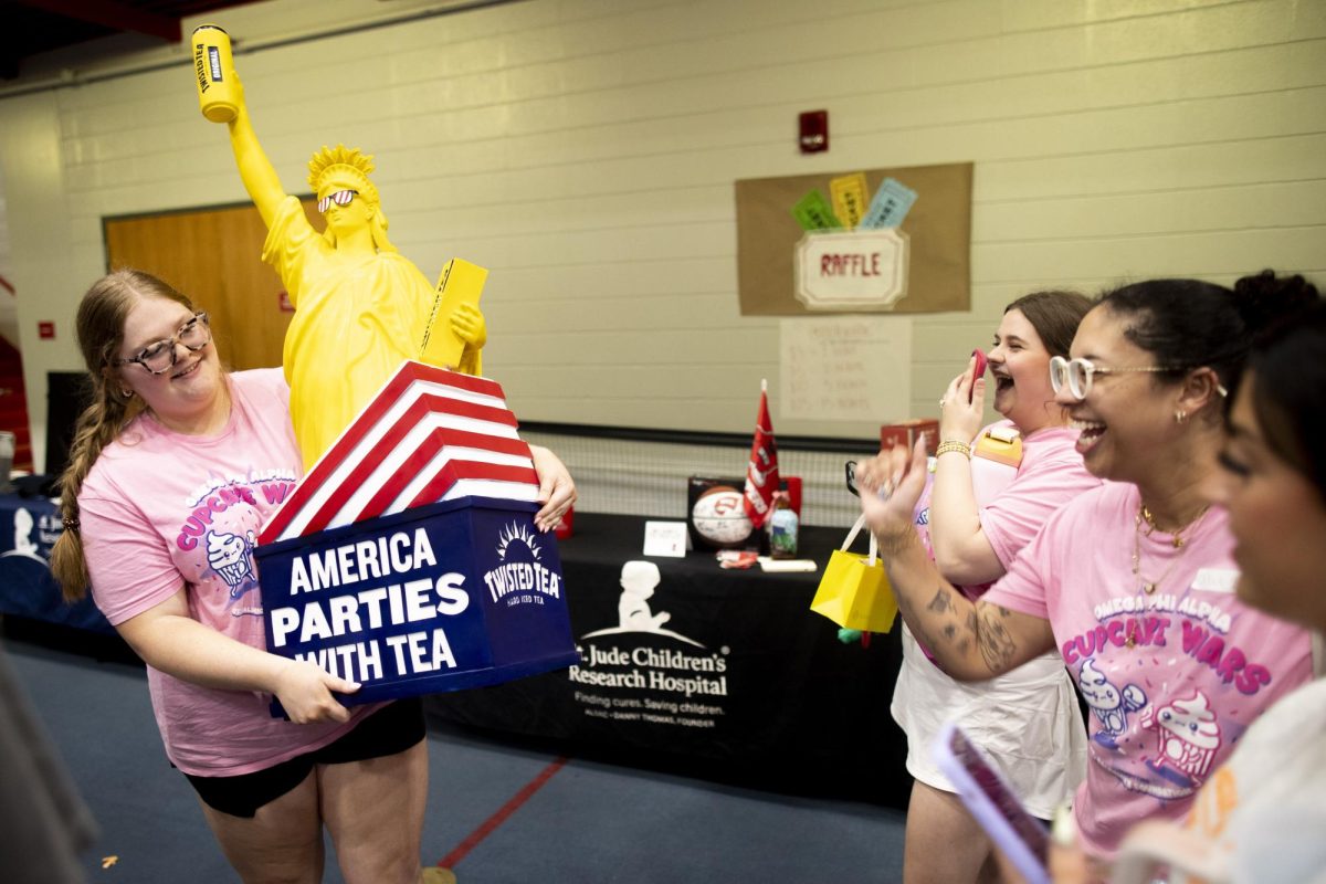Sophomore english and secondary education major Hayley Barton holds up the fruits of her raffle bid: the “Statue of LiberTWEA,” as her Omega Phi Alpha sorority sisters cheer her on after the “Midnight on the Hill” fundraising event for St. Jude Children’s Research Hospital in the Preston Fitness Center on Saturday, April 5, 2025. Barton purchased 100 dollars worth of raffle tickets to secure the Twisted Tea themed statue, the proceeds of which were donated to St. Jude’s charities. 