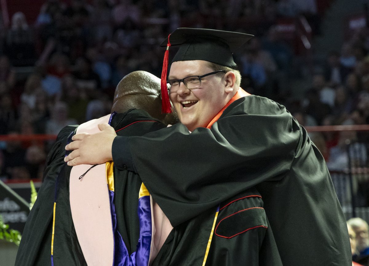 Photojournalism Major Brett Phelps laughs after hugging Dean Terrance Brown during the Potter College of Arts and Letters recognition ceremony on Friday, May 9, 2025.