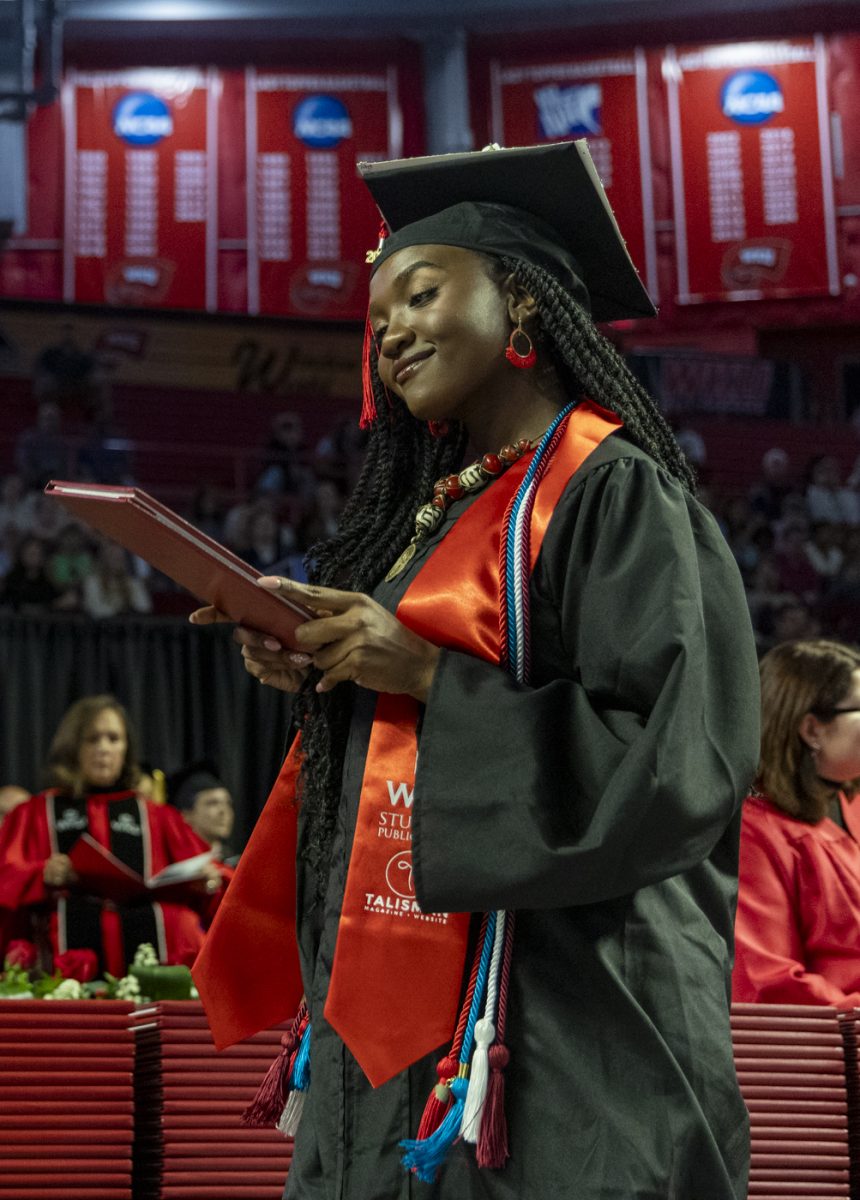Potter College of Arts and Letters graduate Cecila Alali smiles at her diploma during the PCAL recognition ceremony on Friday, May 9, 2025.