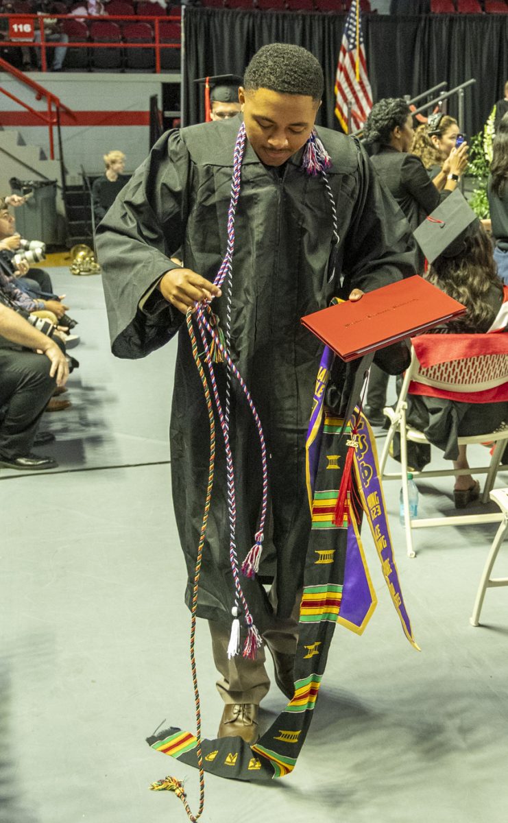 Potter College of Arts and Letters Graduate Isaiah Kindle, member of Omega Psi Phi Fraternity Inc., gathers his graduation regalia after stepping during the PCAL recognition ceremony on Friday, May 9, 2025.