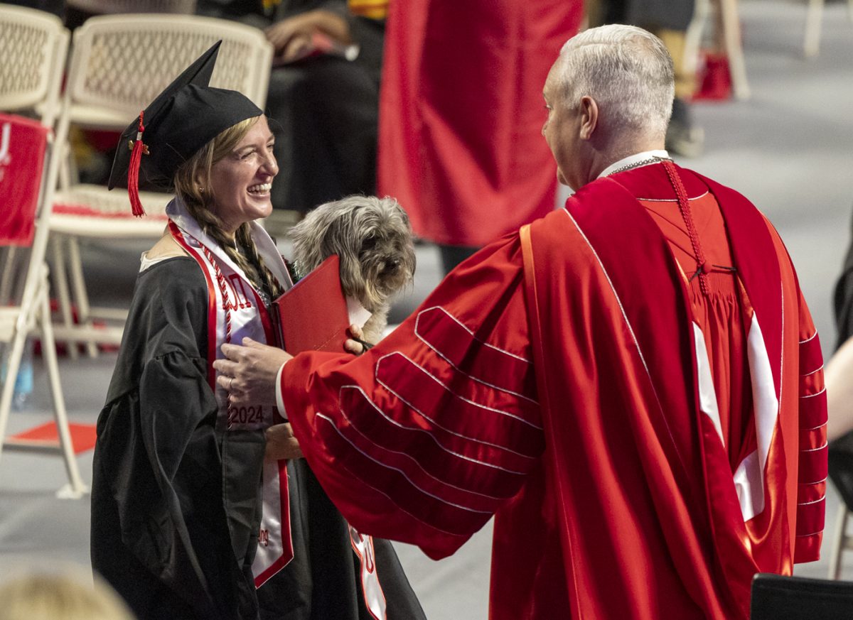 Lorilee King-Beckman smiles and holds her service dog Dick Van Dyke as she walks across the stage during the PCAL recognition ceremony on Friday, May 9, 2025.